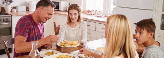 Family With Teenage Children Eating Meal In Kitchen